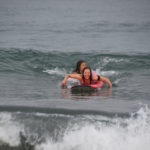 Paddling for a wave in surf lesson